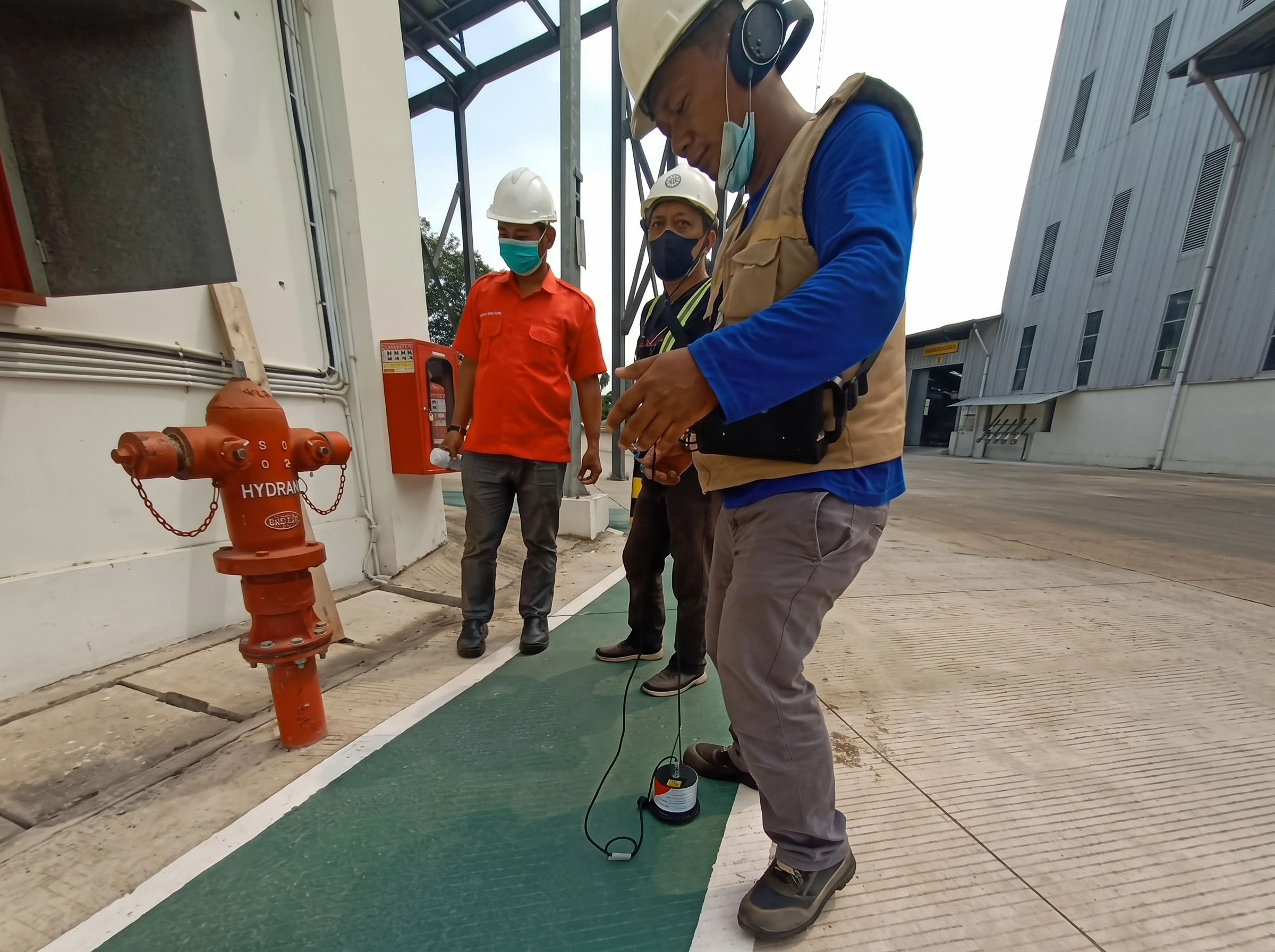 Teknisi mendeteksi kebocoran pipa hydrant di kawasan industri dengan acoustic leak detector